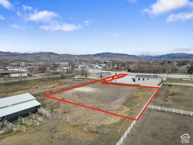 Expansive lot featuring a single-story structure, direct road frontage, and mountain backdrop