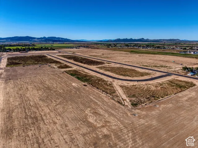 Expansive undeveloped land featuring paved roads and distant mountain backdrop