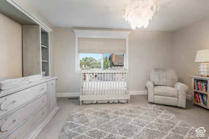 Recessed lighting, crown molding, built-in shelving, window with roller shade, and plush carpet flooring