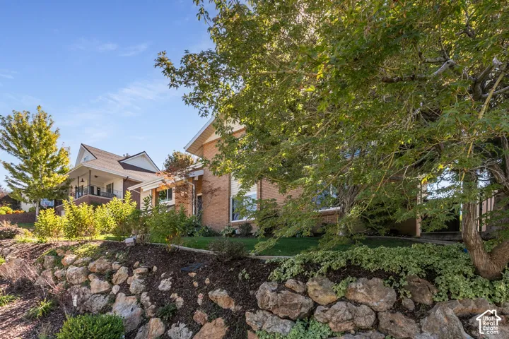 Stone retaining wall with established landscaping and mature trees