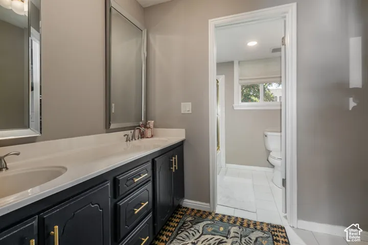 Dual vanity with a white countertop and dark cabinetry