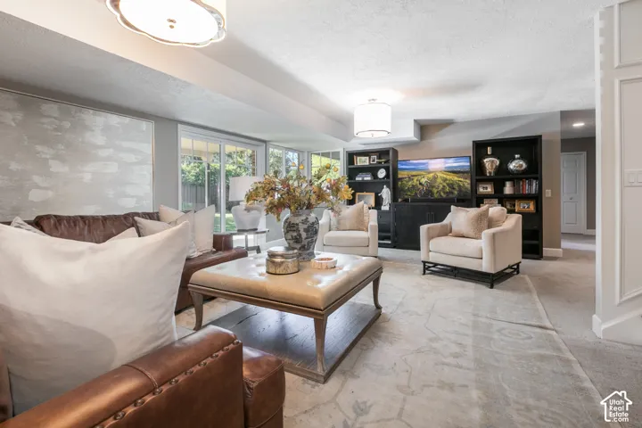 Spacious living area featuring recessed lighting, a ceiling-mounted light fixture, and glass sliding doors