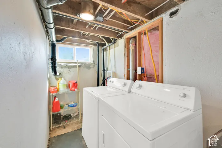 Laundry area featuring a window, exposed ceiling joists, and a light fixture