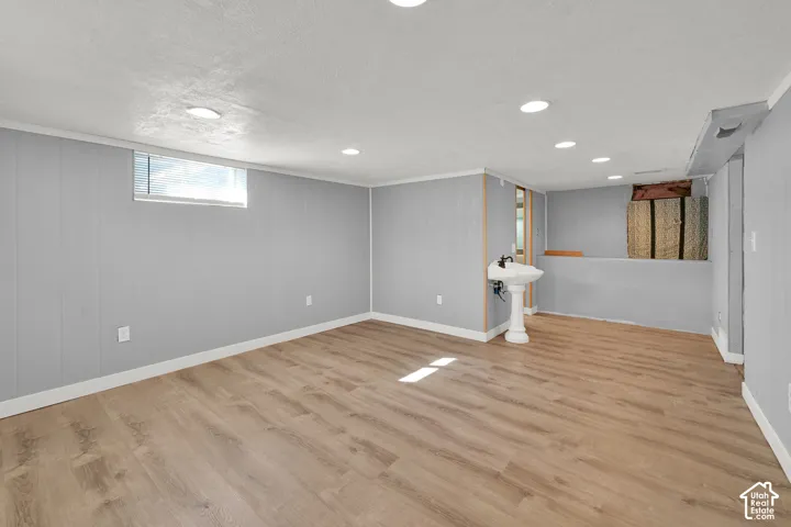 Spacious room with wood-finish flooring, recessed lighting, and light grey paneled walls