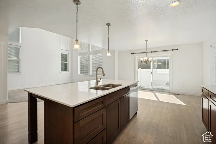 Kitchen island with integrated double sink, quartz countertop, and pendant lighting