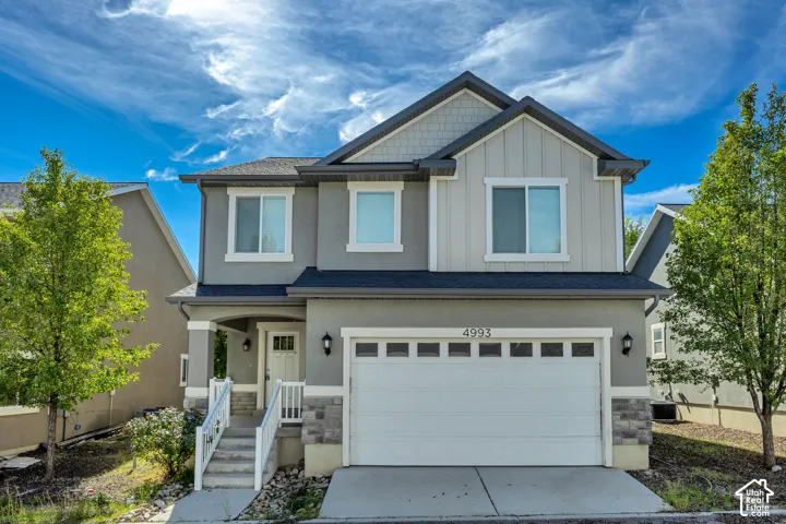 Multi-level stucco and siding exterior with stone accents