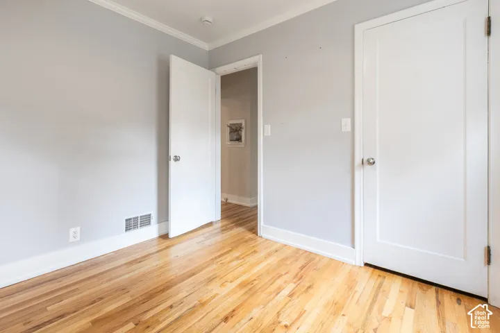 Wood-finish flooring, white trim, and light gray walls