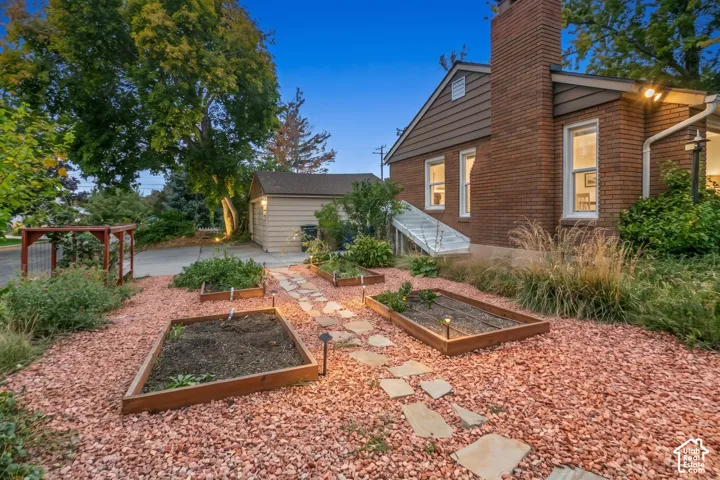 Brick exterior with a prominent chimney, multiple windows, and a basement access