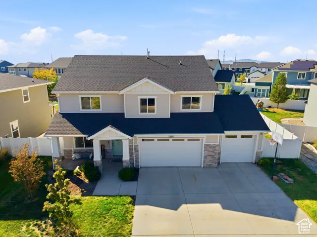 Two-story home with a two-car garage, covered porch, and a light-toned exterior finish