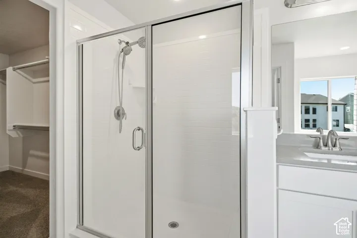 Glass-enclosed shower with subway tile surround, brushed nickel fixtures, and a built-in shelf