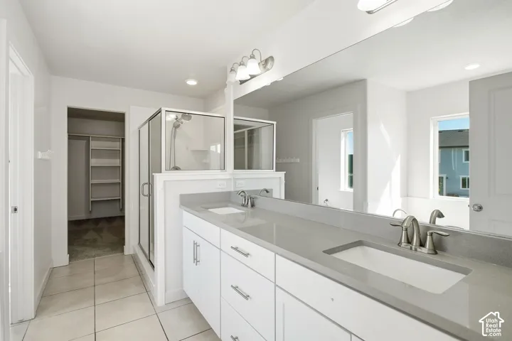 Dual vanity with stone-finish countertops, white cabinetry, and brushed nickel fixtures