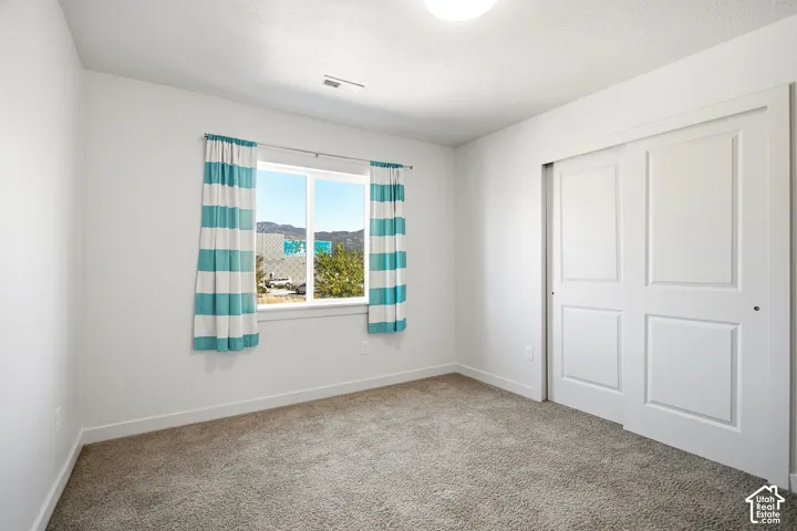 Plush carpeting, bright white walls, and a window with natural light
