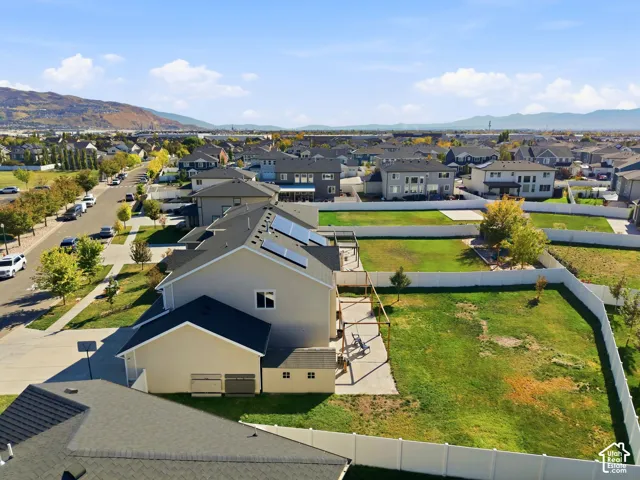 Property featuring a neutral-toned exterior, dark shingle roof, and solar panel installation