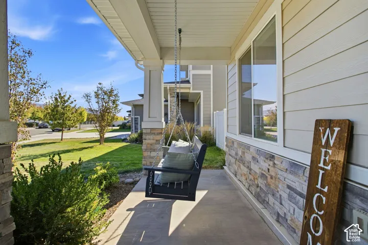 Covered front porch featuring a porch swing and stone veneer siding