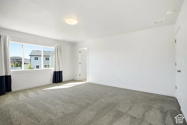 Light gray carpeted flooring, white painted walls, and a contemporary ceiling light fixture