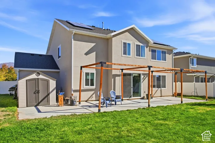 Expansive concrete patio with a wooden pergola structure