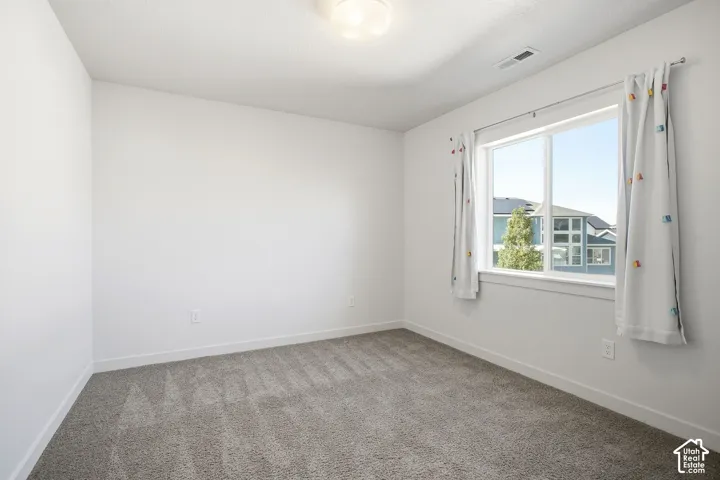 Recessed lighting, light gray carpet, white walls, white trim, and a window