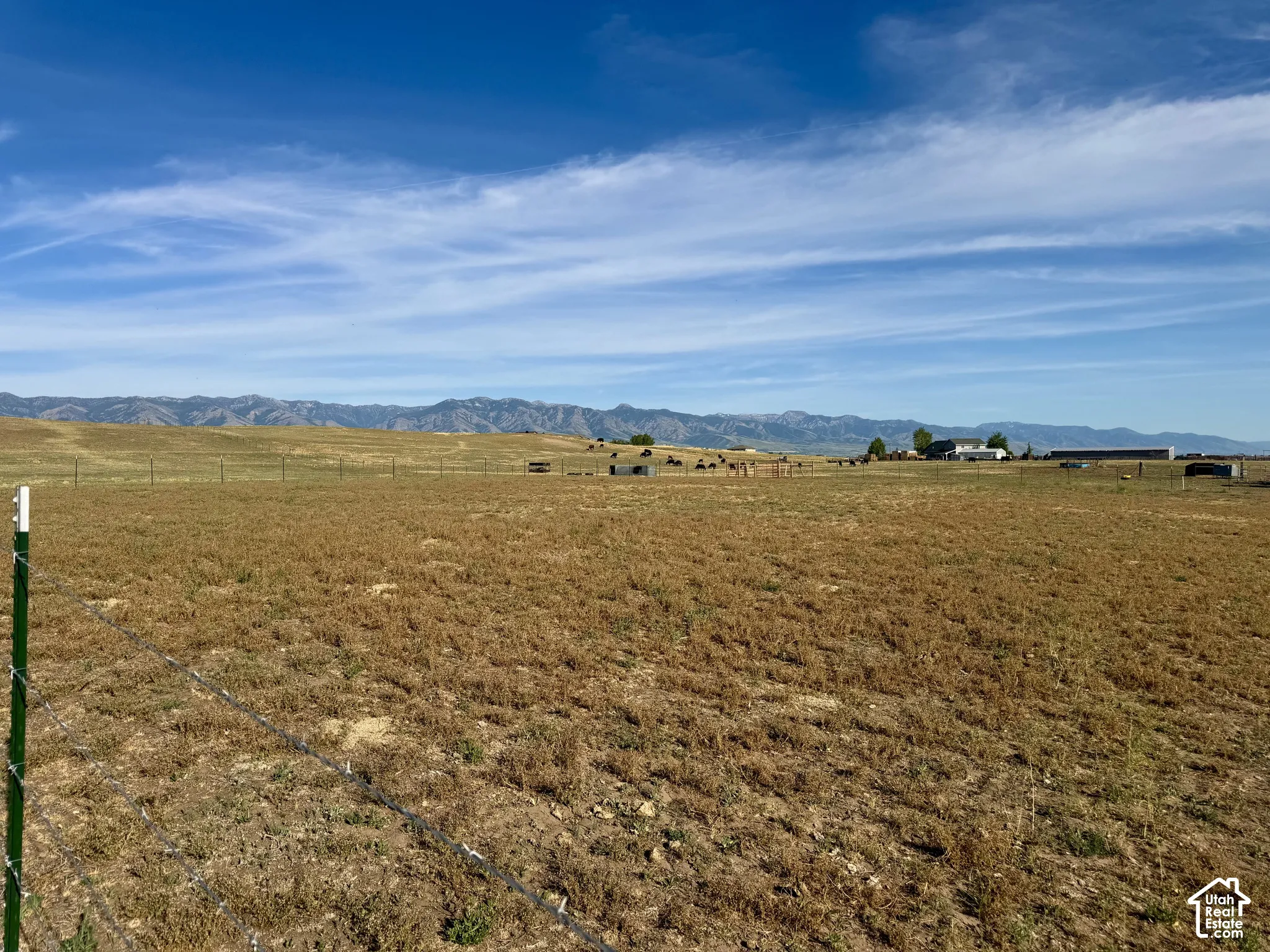 Expansive open land featuring distant mountain scenery and clear blue skies