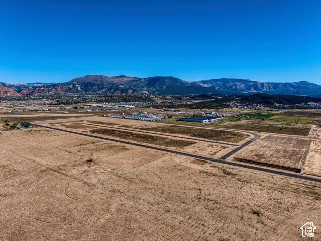 Expansive land parcel with existing roadways and a distant mountainous backdrop
