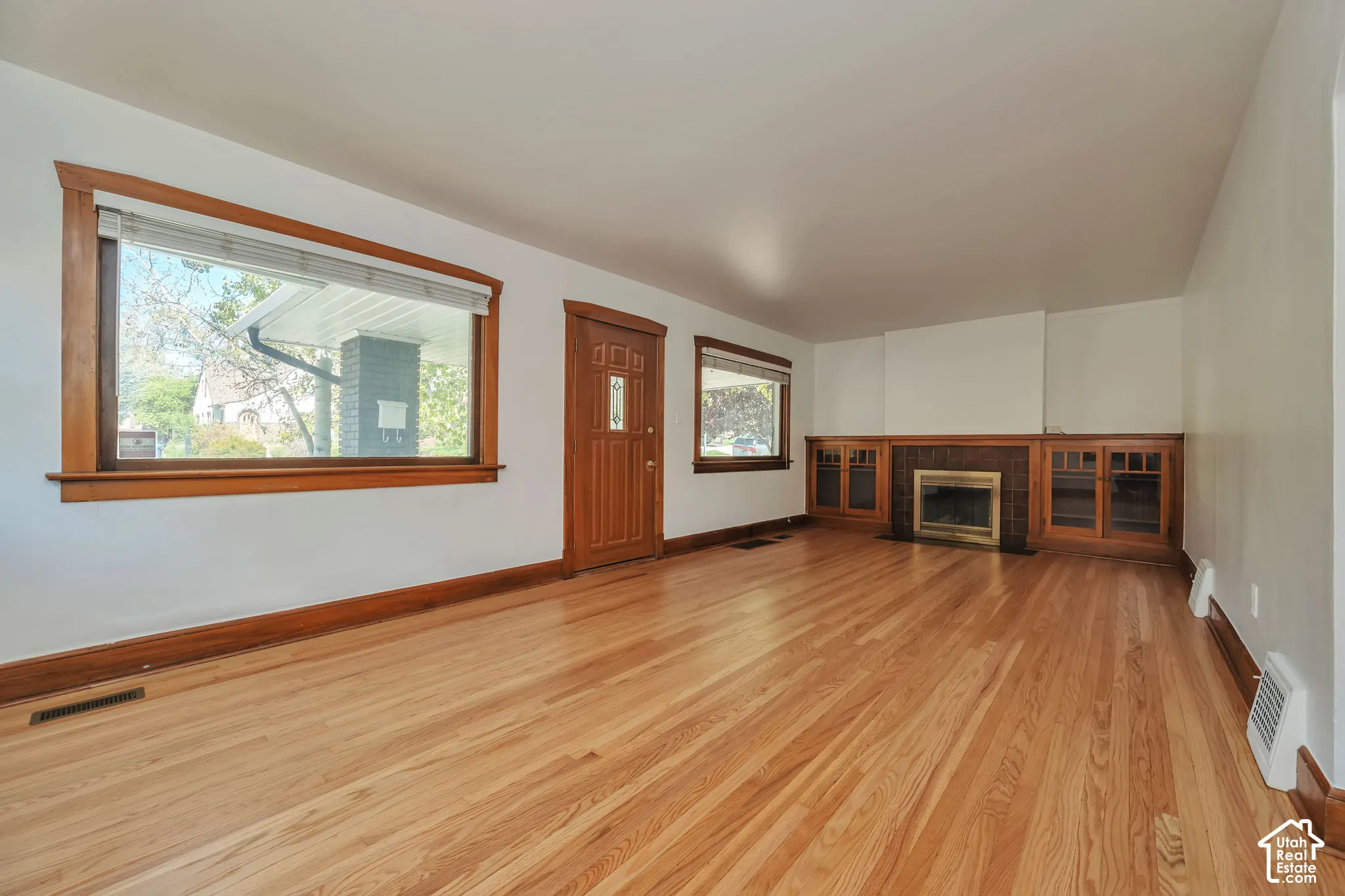 Newly re finish hardwood flooring, wood trim, built-in gum wood cabinetry, fireplace, and large windows.