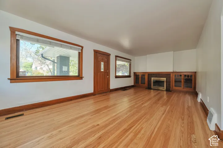Newly re finish hardwood flooring, wood trim, built-in gum wood cabinetry, fireplace, and large windows.