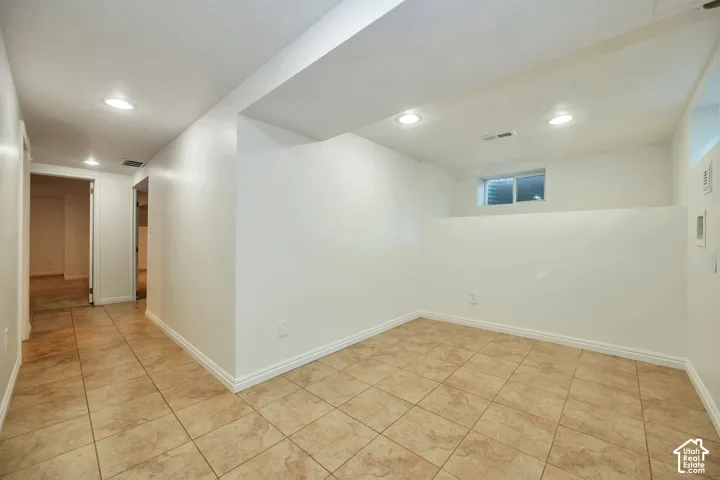 Tiled flooring throughout, recessed lighting, and a window for natural illumination