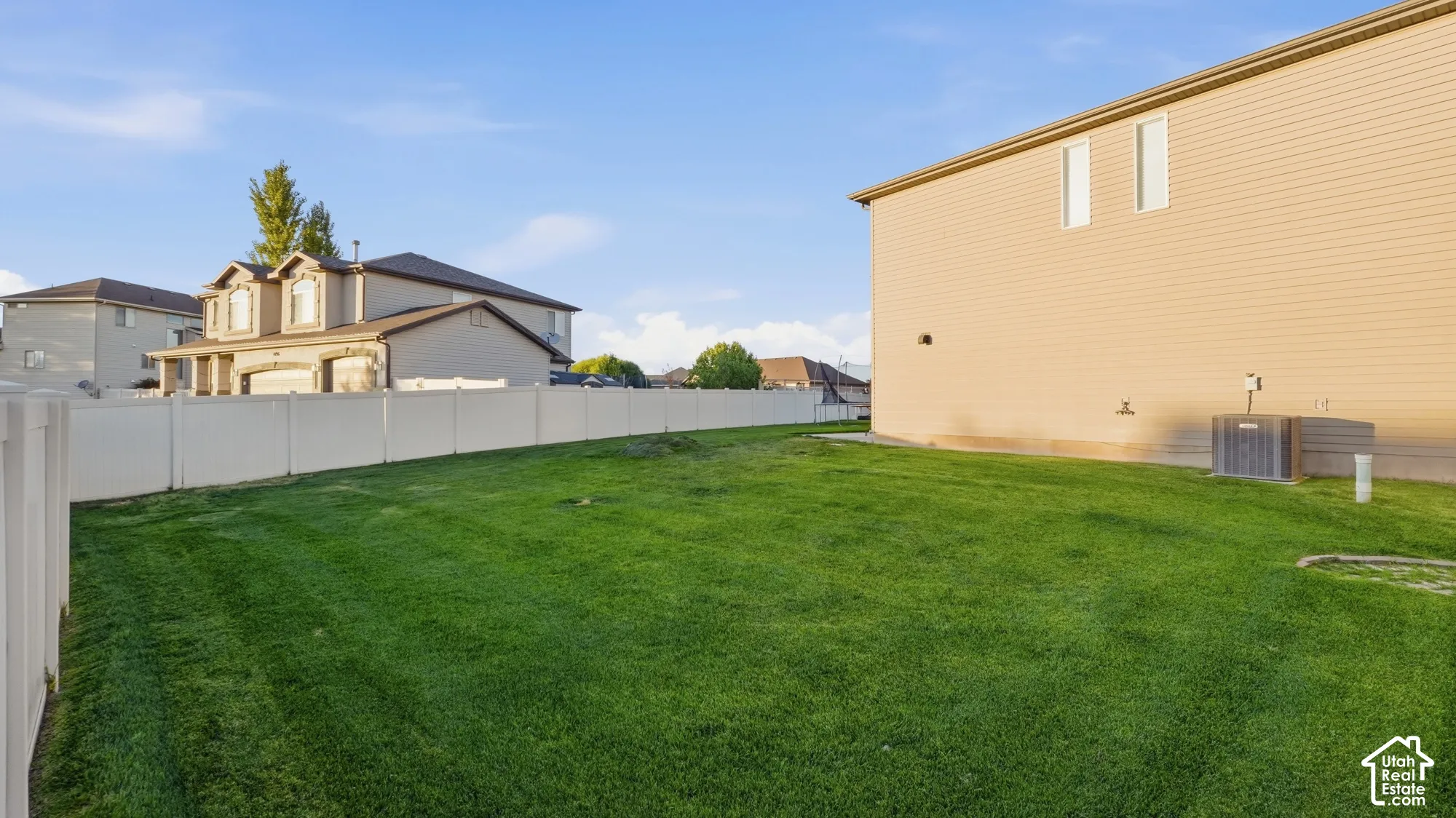 Expansive green lawn with vinyl fencing