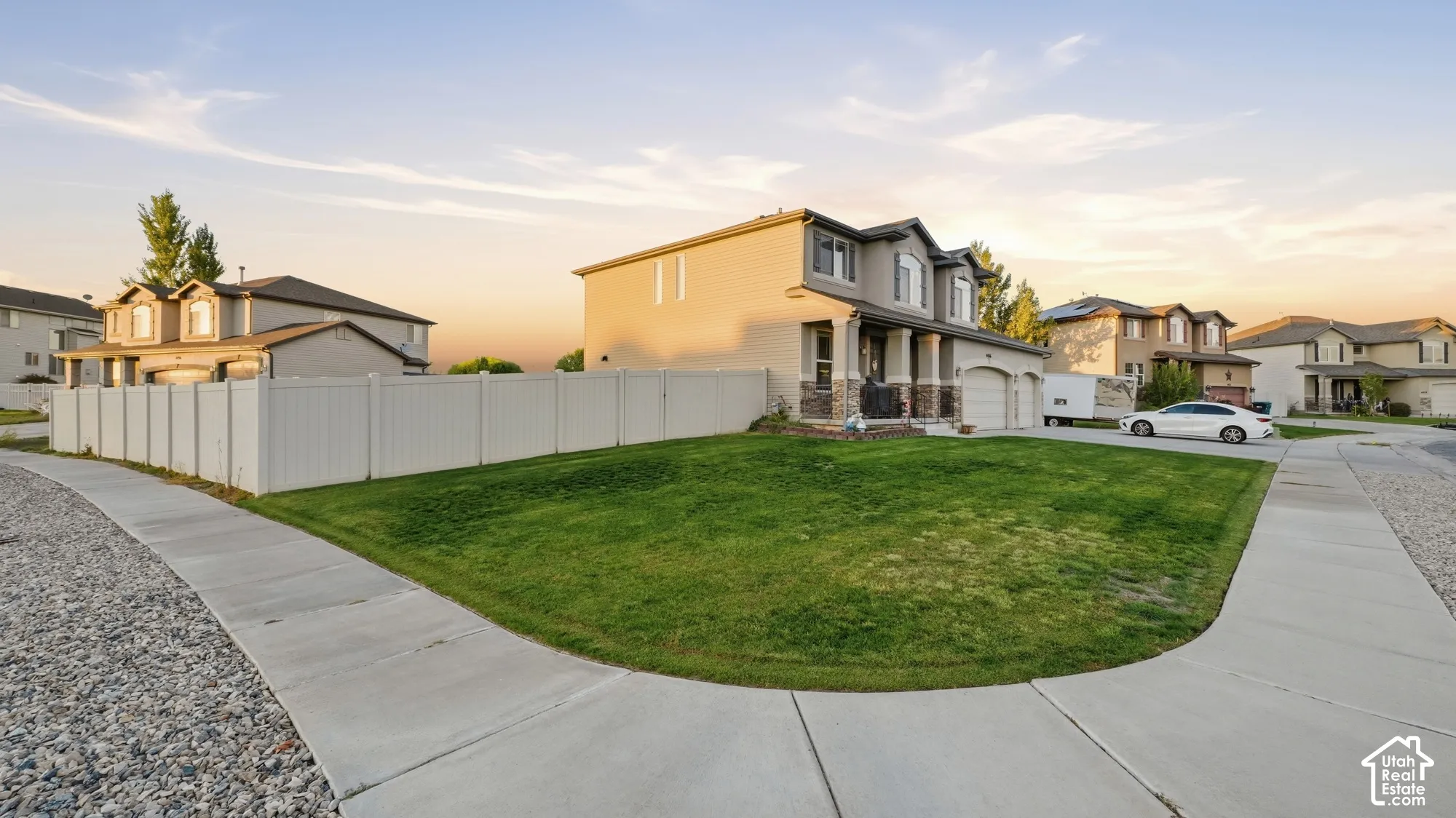Two-story residence with a multi-car garage, stone accents, and a covered porch entry