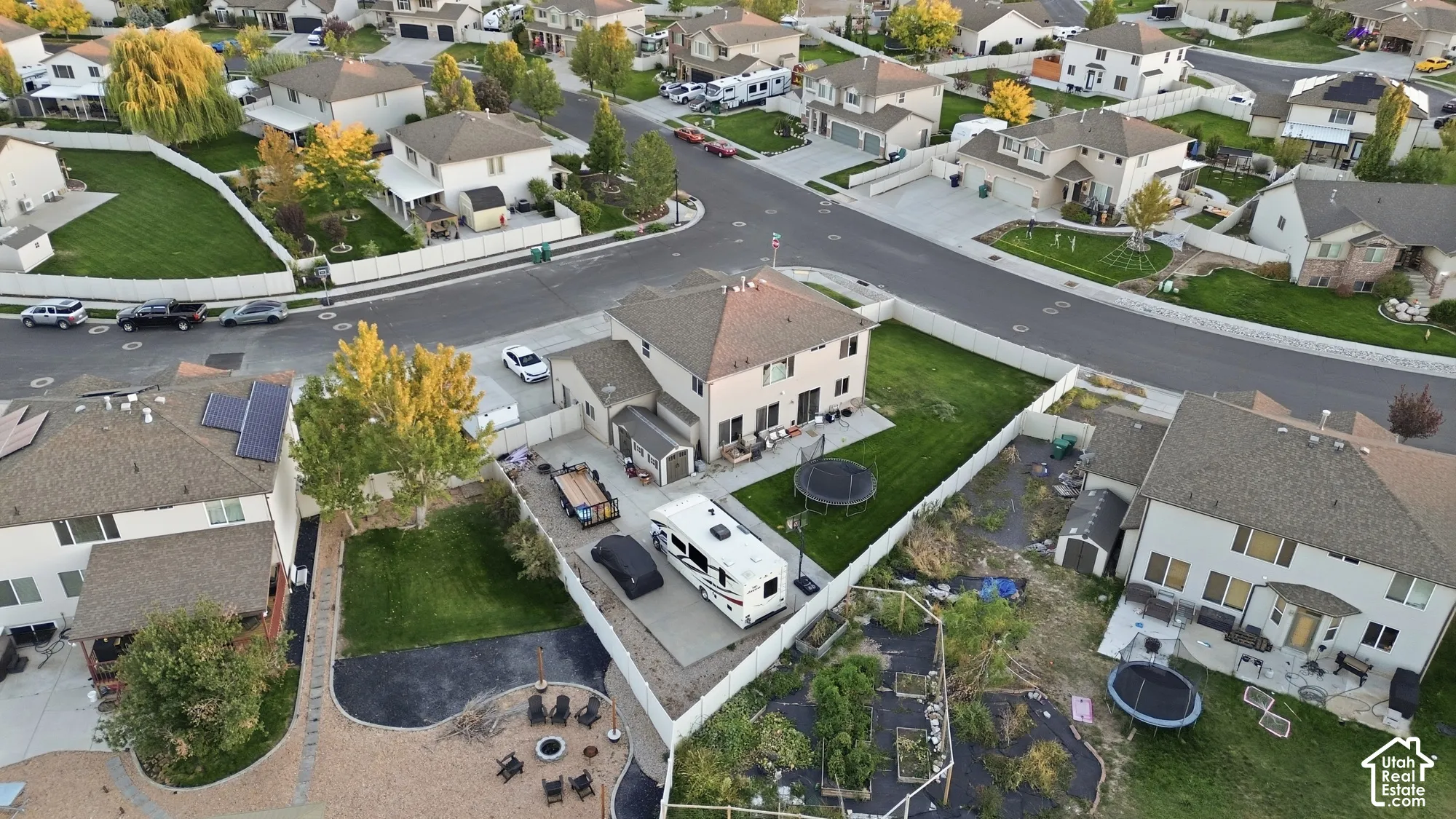 Corner lot residence featuring a two-story design, attached garage, and a fenced backyard with a patio