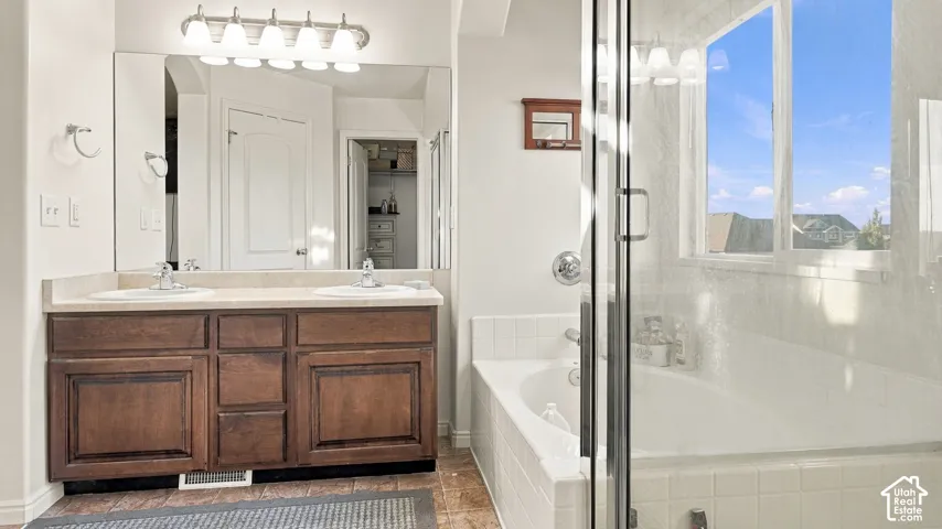 Dual vanity with wood-finish cabinetry, a large mirror, and a five-light fixture