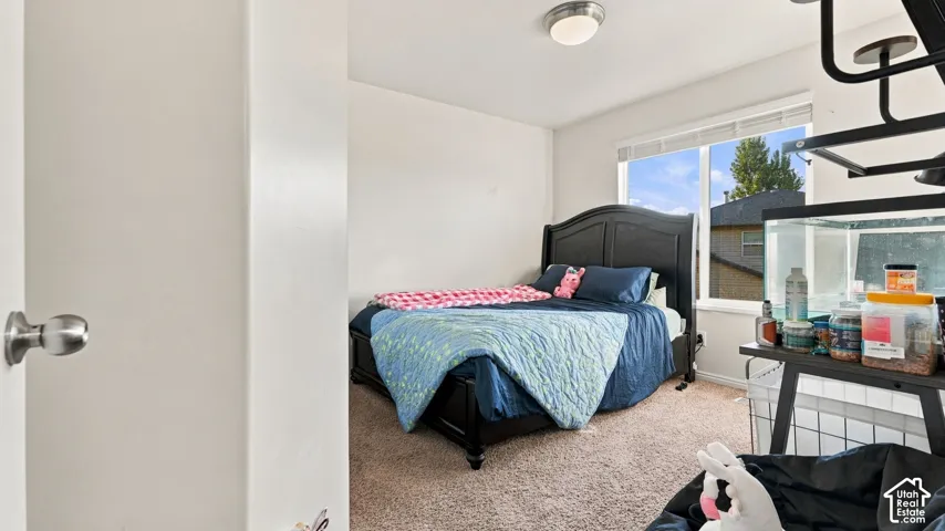 Bedroom featuring a large window, neutral carpeting, and a flush-mount ceiling light