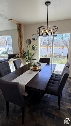 Contemporary chandelier, wood-finish flooring, sliding glass door, backyard access, architectural wood room divider