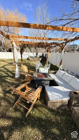 Wood pergola structure over a stone-finish fire pit