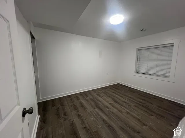 Neutral wall finishes, wood-finish flooring, recessed ceiling light, and window with blinds