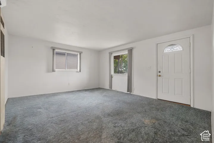 White paneled entry door with an arched decorative glass insert, complemented by a brass-finish doorknob