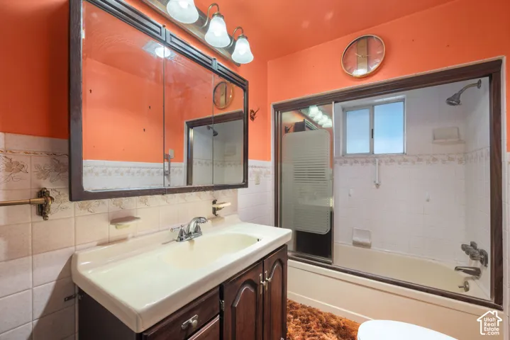 Vanity with a built-in sink, wall-mounted mirror, and overhead light fixture