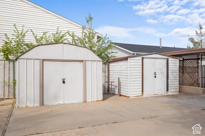 Two metal storage sheds on a concrete pad