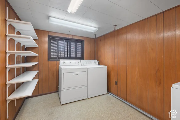 Wood-paneled room with built-in shelving, a double window, and a drop ceiling with fluorescent lighting