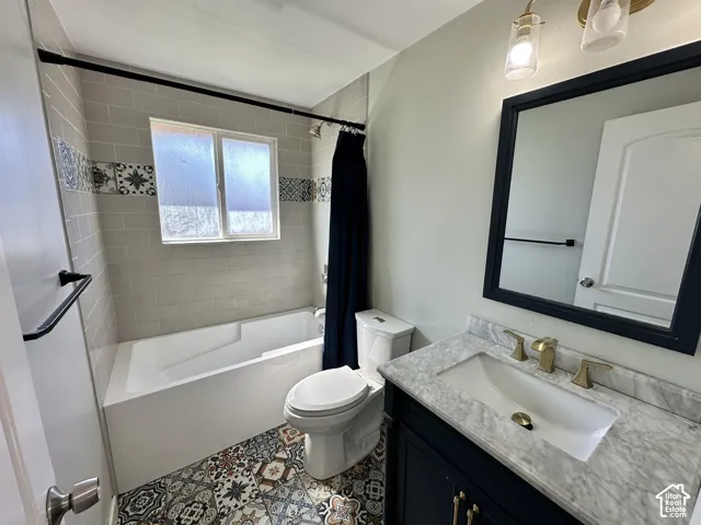 Bathroom featuring a vanity with a white countertop, gold-finish faucet, and a framed mirror