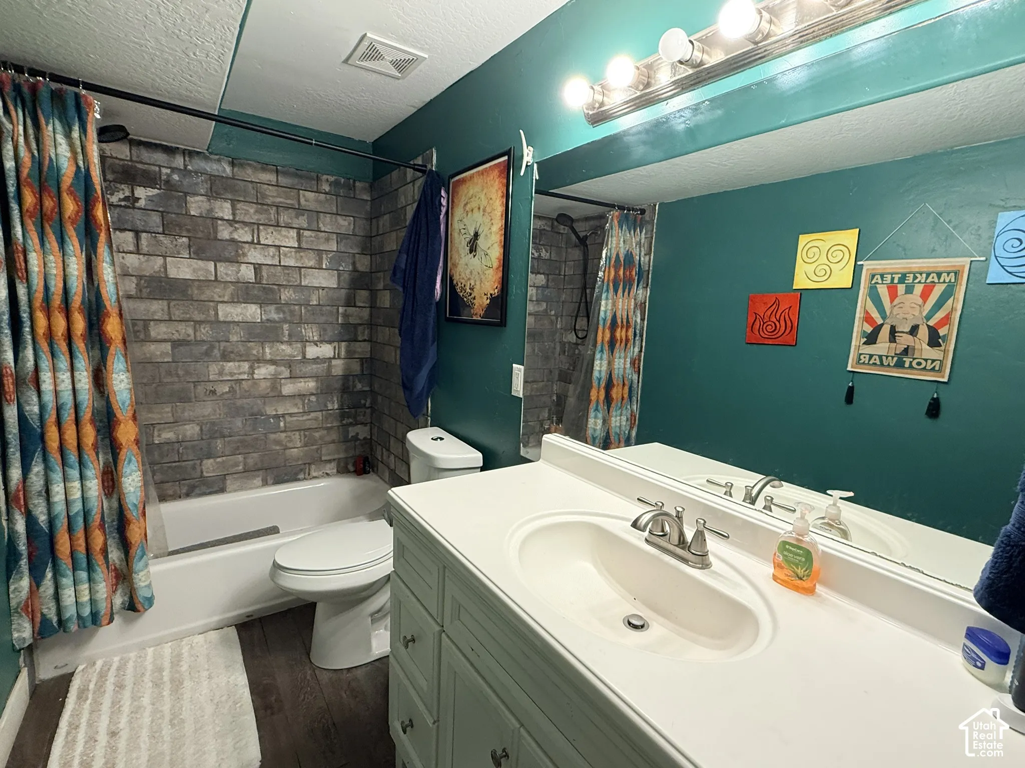 Bathroom featuring a white vanity with integrated sink, a single-handle faucet, and an overhead vanity light bar