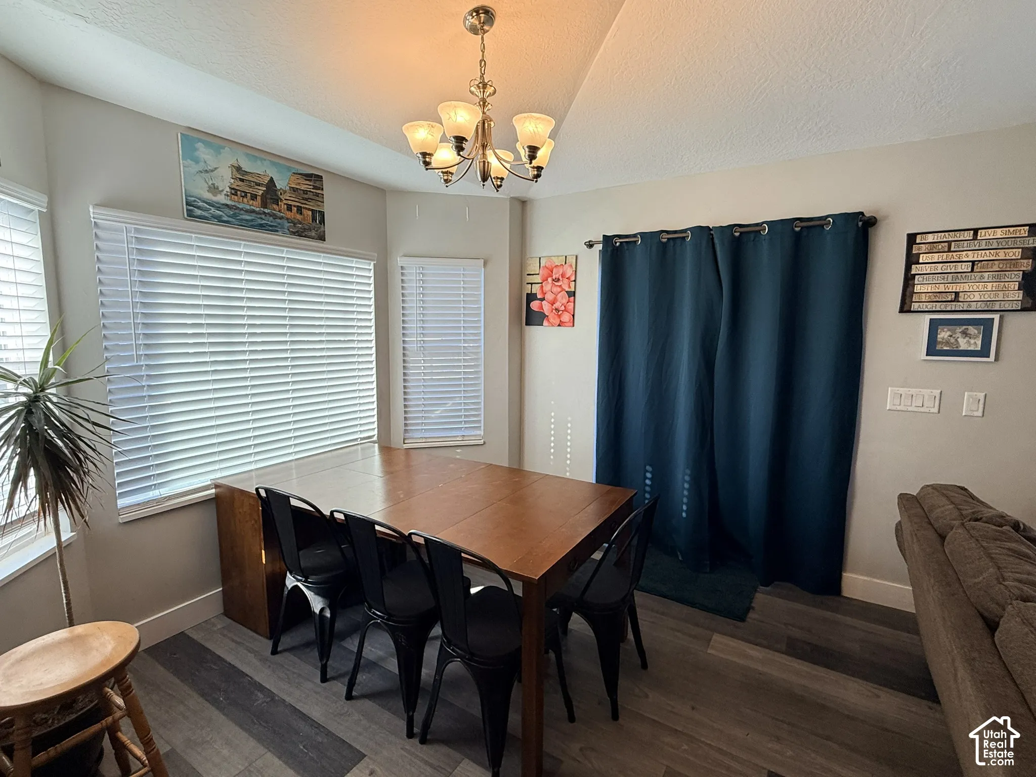 Wood-finish flooring throughout, multiple windows with blinds, and a built-in chandelier