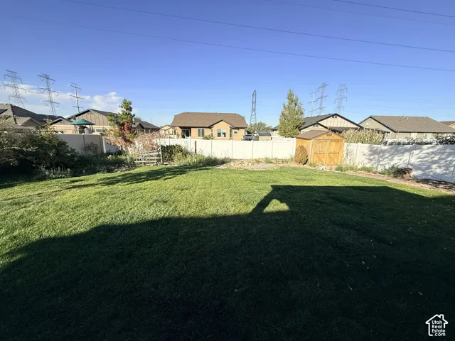 Expansive grass lawn with a wood-sided shed and perimeter fencing
