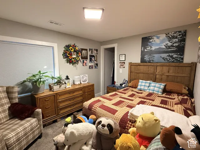 Recessed window with privacy blinds, wood-finish headboard, and a flush-mount ceiling light