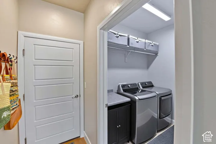 Laundry area featuring a built-in shelf, counter space, and cabinet storage