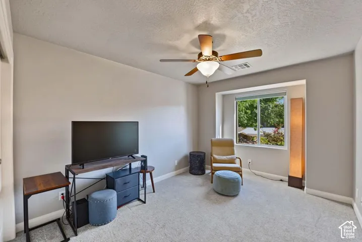 Recessed window with ample natural light, ceiling fan with integrated lighting, carpeted flooring, and neutral wall tones