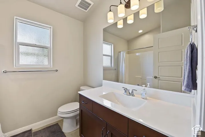 Dark wood-finish vanity with an integrated sink, polished chrome faucet, and expansive mirror
