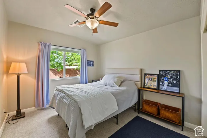Carpeted room with a ceiling fan, a window, and light-toned walls