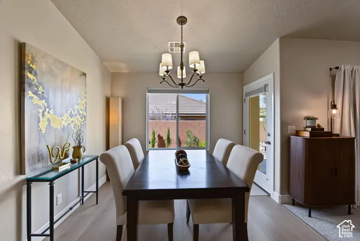 Recessed lighting, wood-finish flooring, and a large window with roller shades