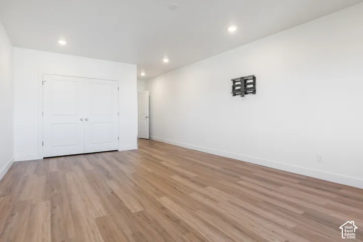 Wood-finish flooring, recessed lighting, and white walls