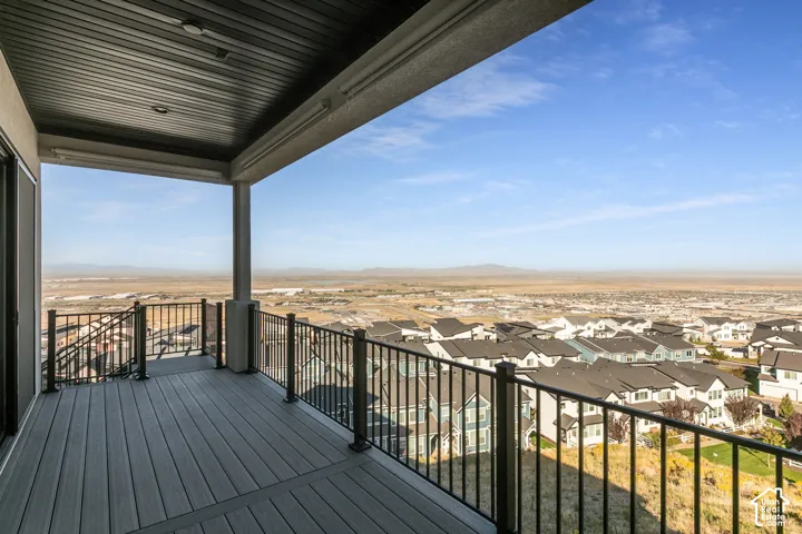 Covered deck featuring composite decking, black metal railings, and integrated overhead lighting.  Panoramic views.